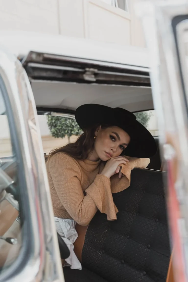 woman in hat sitting in car
